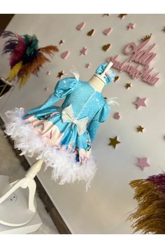 a blue dress with white feathers on it and happy birthday sign in the back ground