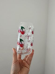 a hand holding up a wine glass with cherries on it