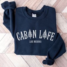 🎅Last day for Christmas orders Dec 8th🎄 Our Personalized Cabin Life Sweatshirt is Customizable to add any name you would like. Our cabin sweater is great to wear camping to stay cozy around the campfire. This would also make the perfect personalized cabin gift for Christmas or for the new cabin owner. ♡ PRODUCT: Unisex heavy blend crewneck sweatshirt is pure comfort. These garments are made from polyester and cotton. This combination helps designs come out looking fresh and beautiful. The coll Cabin Sweater, Cabin Gifts, Cabin Christmas, Around The Campfire, Cricut Joy, Cabin Life, Name Gifts, Gift For Christmas, Camping Shirt