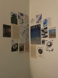 a white wall with many different pictures on it and some papers attached to the wall