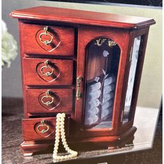 an old fashioned wooden jewelry cabinet with pearls