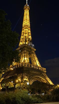 the eiffel tower lit up at night with lights on it's sides