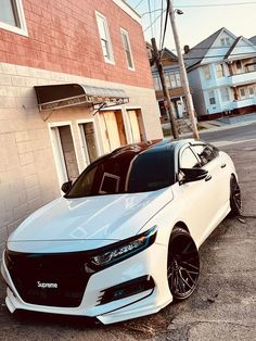 a white car parked in front of a brick building