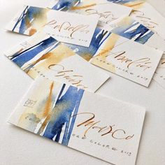 four watercolor business cards with calligraphy on them