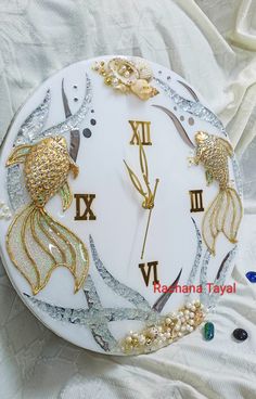 a white clock with gold and silver decorations on it