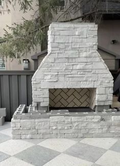 a man standing next to a brick oven on top of a tiled floor in front of a building