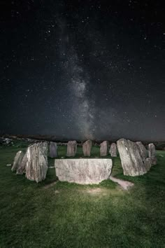 the night sky is filled with stars above stonehenge in an open grassy field