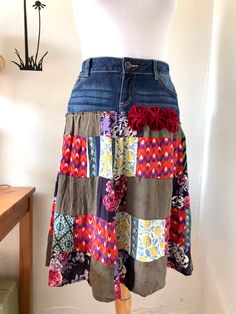 a woman's skirt made out of patchwork fabric and denim with flowers on it