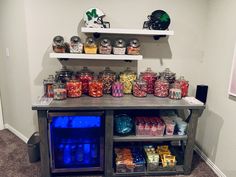 a shelf filled with lots of candy on top of a carpeted floor next to a wall