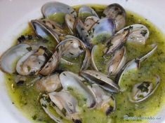 a white bowl filled with clams and sauce