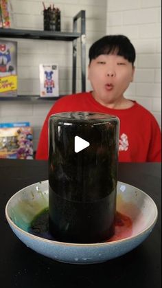 a person sitting at a table in front of a black object