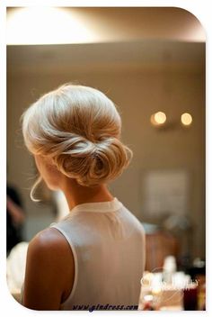 the back of a woman's head with her hair in a low bun