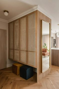 a room with wood flooring and a large mirror on the wall next to it