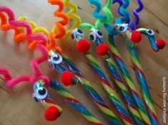 several different colored straws with eyeballs and candy canes on a wooden table