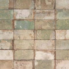 an old tile wall that has been painted green and brown with white squares on it