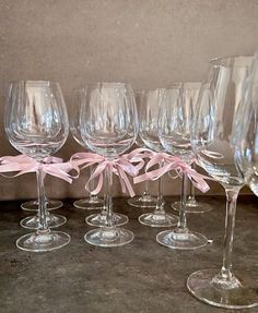 there are many wine glasses with pink bows on them