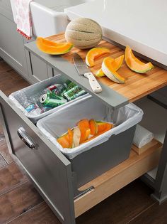 a kitchen counter with two bins filled with fruit