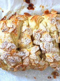 a pastry with almonds and powdered sugar on top