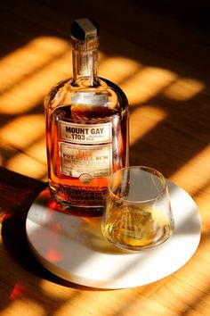 a bottle of whiskey sitting on top of a white plate