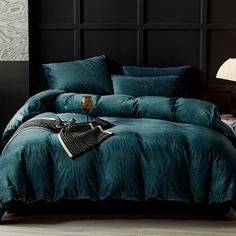 the bed is made with teal colored sheets and pillows