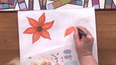 a child is drawing with colored pencils on paper