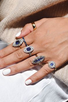 a woman's hand with five different rings on her fingers and one has an evil eye