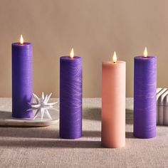 three purple candles sitting next to each other on a table