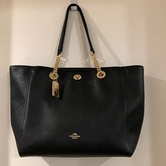 Black Genuine Leather Coach Turnlock Chain Tote With Original Dust Bag. Approximately 12 1/2” X 12” X 4 1/2” With A 10” Handle Drop. Three Inside Pockets, One With A Zipper. Zippered Closure As Well As A Full Front Pocket With A Turnlock. Gold Chains Enhance The Leather Straps. Excellent Condition. Bags Coach, Leather Coach, Womens Tote Bags, Coach Bags, Inside Pocket, Front Pocket, Gold Chains, Leather Straps, Dust Bag