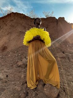 a woman standing on top of a dirt hill