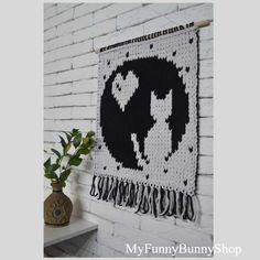 a white brick wall with a black and white tapestry hanging on it