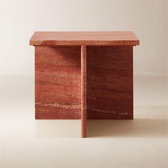 a small wooden box sitting on top of a white floor next to a red wall