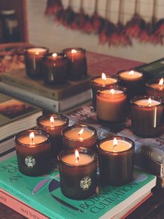 many lit candles are on top of a book and some books sit next to each other