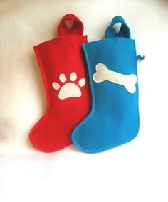 two oven mitts with dog paw prints on them, one blue and one red