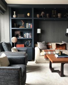 a living room filled with furniture and bookshelves next to a large glass window