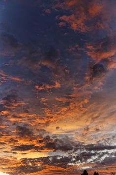 the sun is setting behind some clouds in the sky