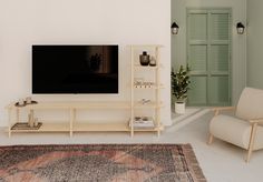 a living room with a large television on top of a wooden entertainment center next to a chair