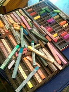 there are many different colored crayons in the box on the table and one is empty