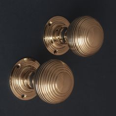 two brass knobs on a black background