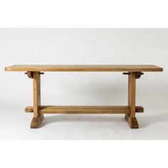 a wooden bench sitting on top of a white floor next to a table with two legs