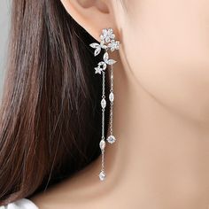 Material: Copper, Rhodium Plated, Cubic ZirconiaSize: 8.6cm by 1.8cmWeight: 6.2gDesign: Crystal Flowers and Leaves on a Chain Drop Dangle Statement Earring Color: White, Silver