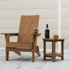 a wooden chair sitting next to a table with two wine glasses on top of it