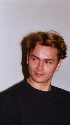 a young man in a black shirt posing for a photo