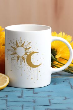 a white coffee mug sitting on top of a table next to yellow flowers and a slice of lemon