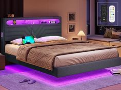 a large bed sitting under a purple light in a bedroom