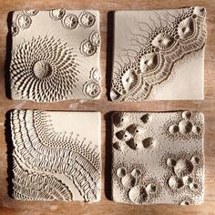 four ceramic coasters with intricate designs on them