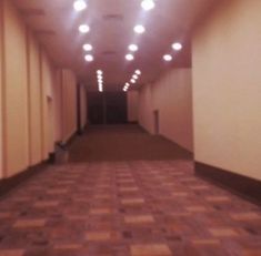 an empty hallway with lights on the ceiling