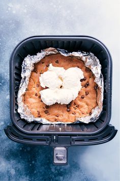 an overhead view of a baked dessert in a container with ice and chocolate chips on top