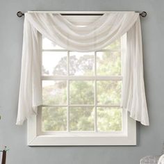 a window with a white curtain hanging from it's side