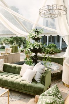 a living room filled with lots of green furniture