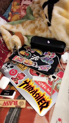 an assortment of stickers and decals on a bed with a stuffed animal in the background